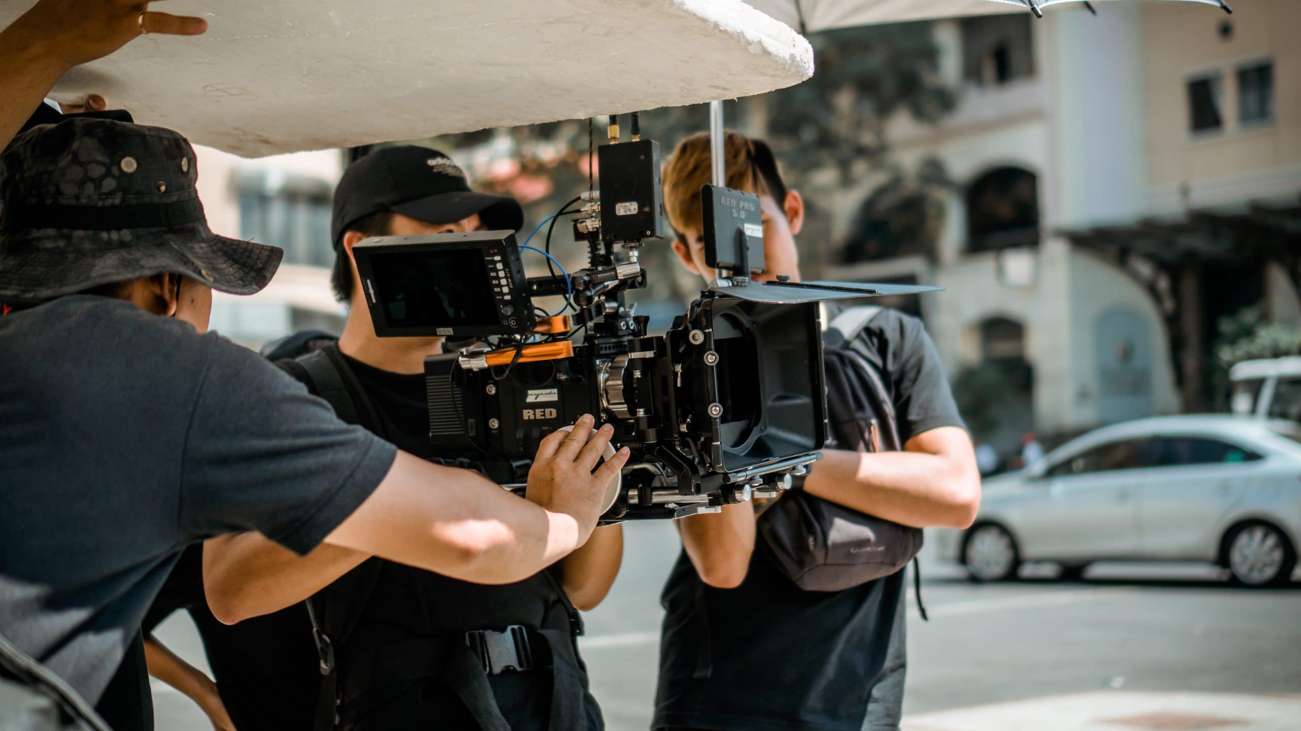 three men from the filming crew are checking the footage.